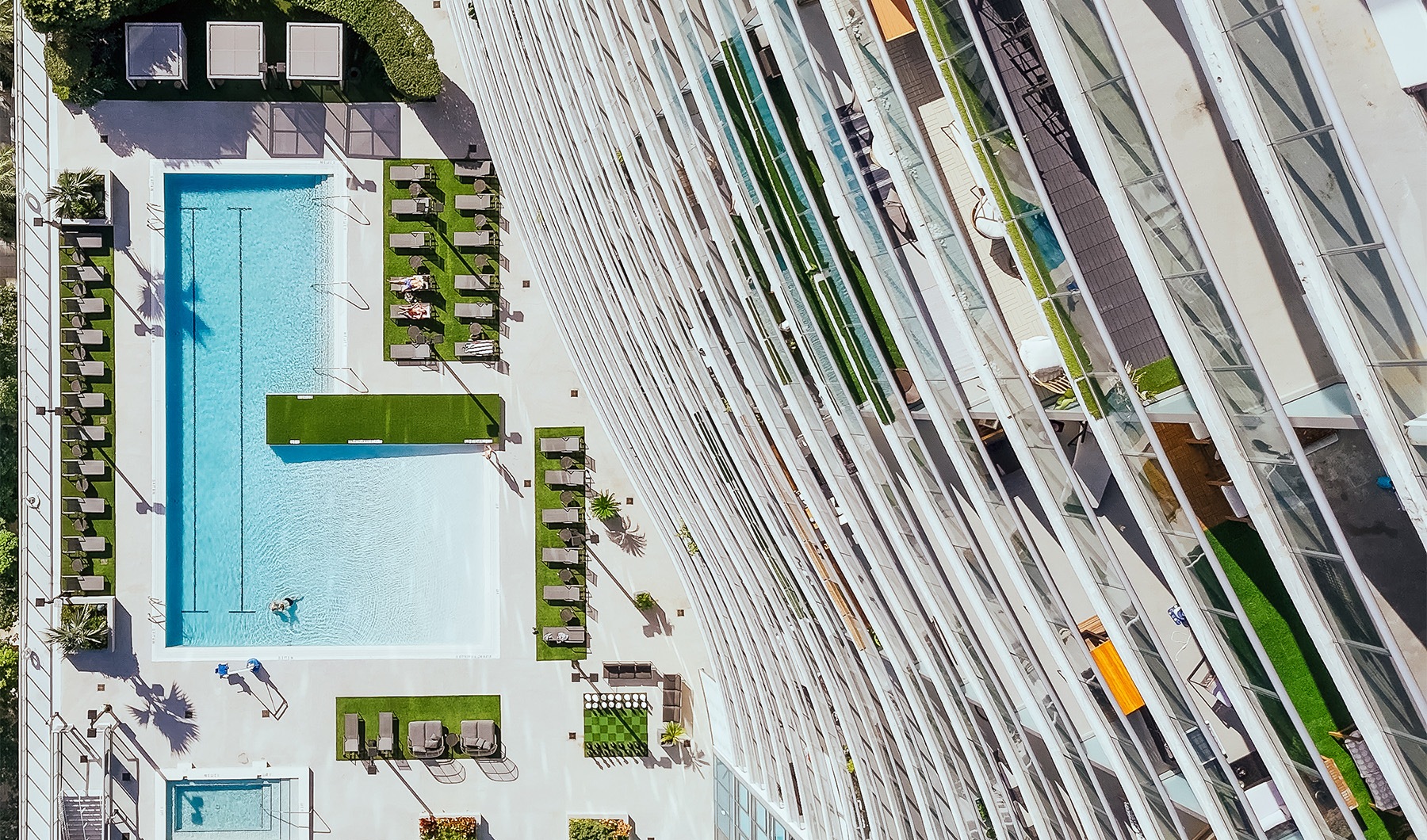 an aerial shot of a building looking down at a pool